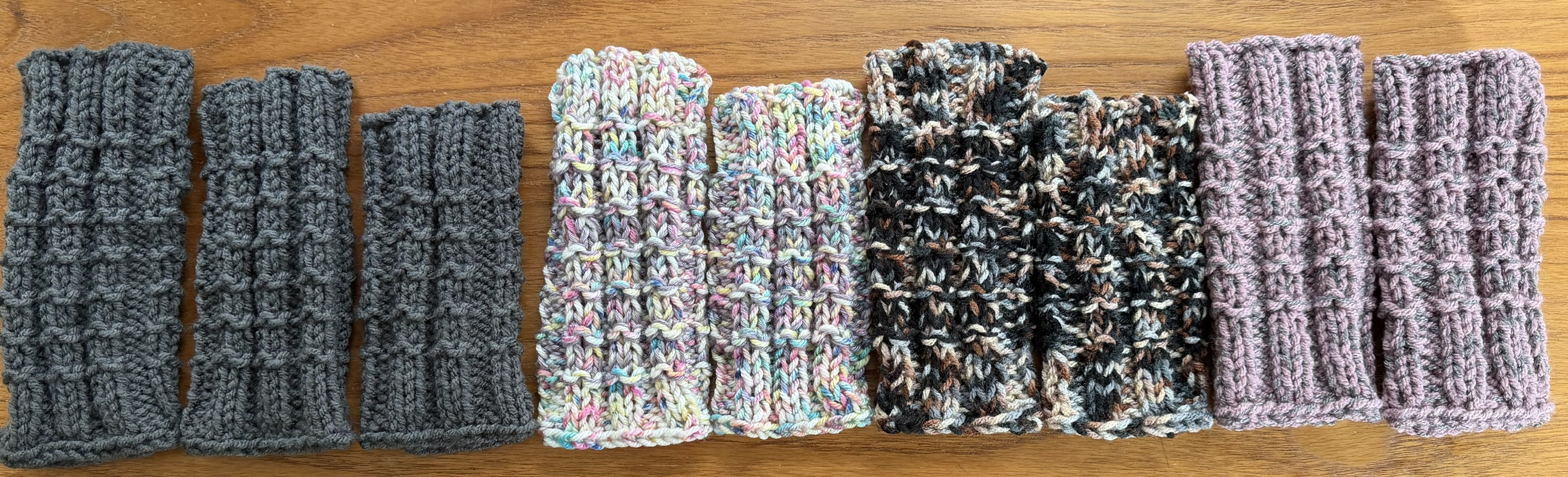 Assorted knitted fingerless gloves in layered neutral and pastel tones